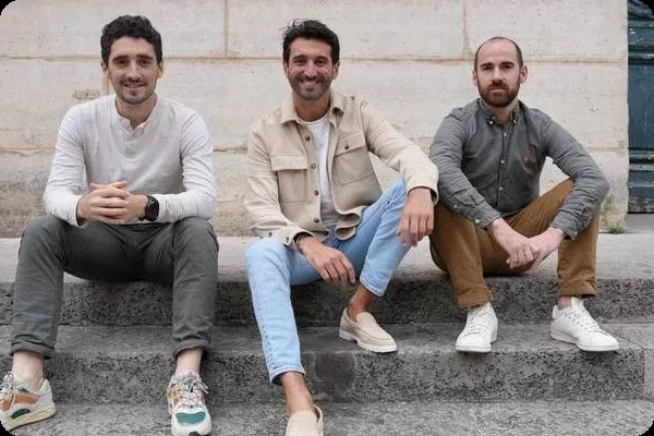 The three co-founders of Fraktion, seated on stone steps